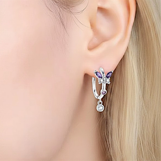 Earring with purple gemstones worn by a person