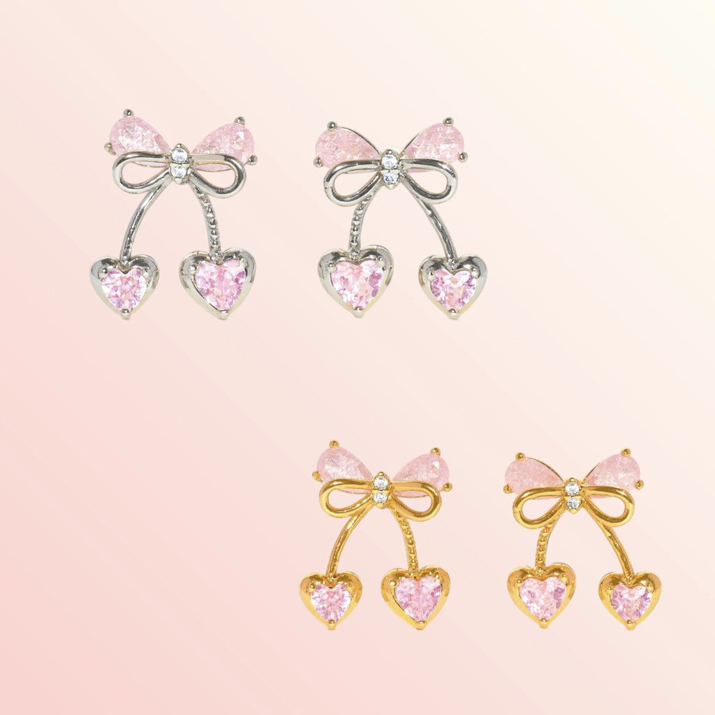 Pair of bow-shaped earrings with pink gemstones on a light pink background