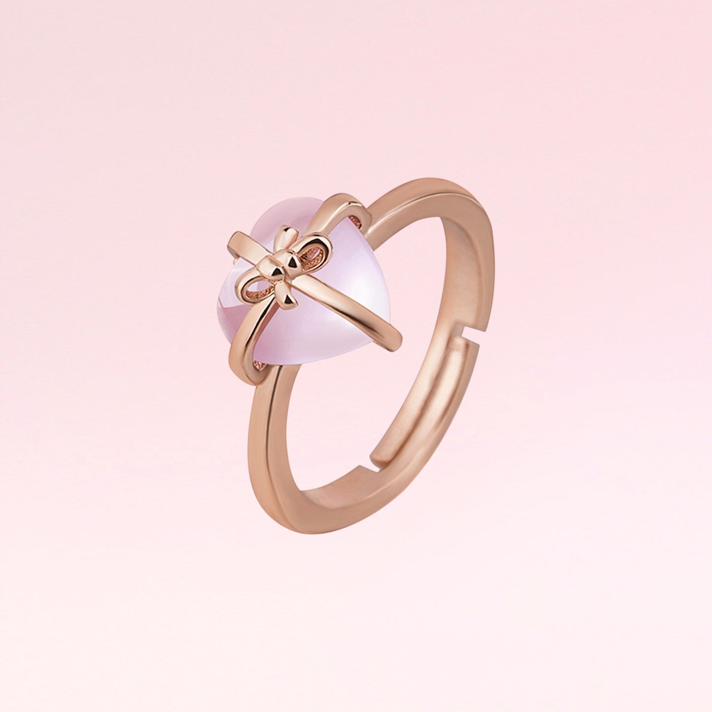 Rose gold ring with a pink gemstone on a light pink background