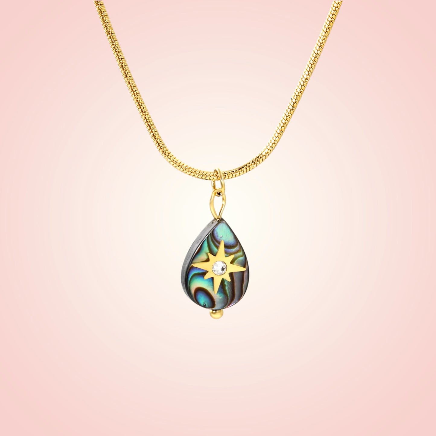 Necklace with a teardrop-shaped pendant on a pink background