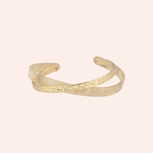 Gold bracelet on a light pink background