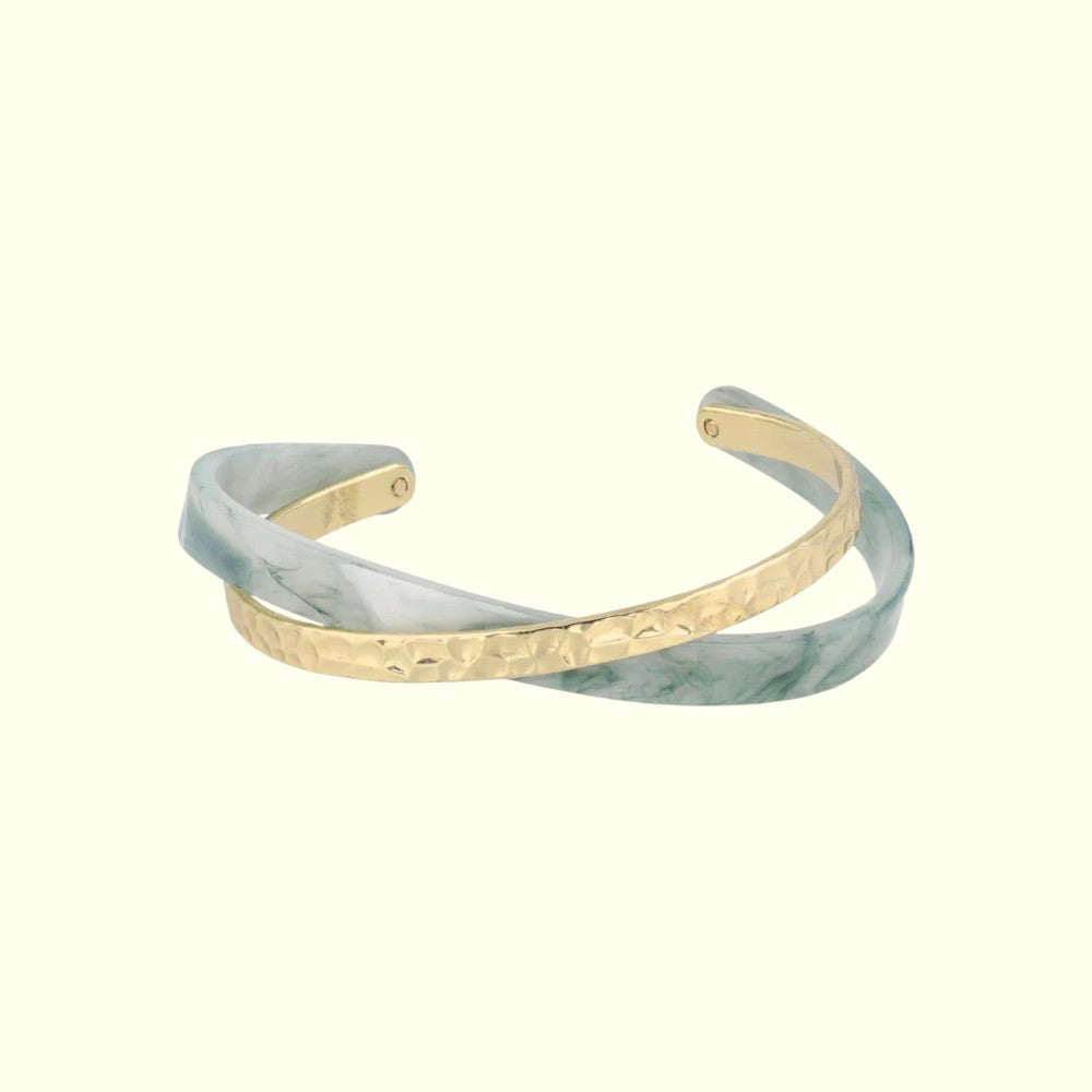 Marble-patterned cuff bracelet with gold accents on a white background