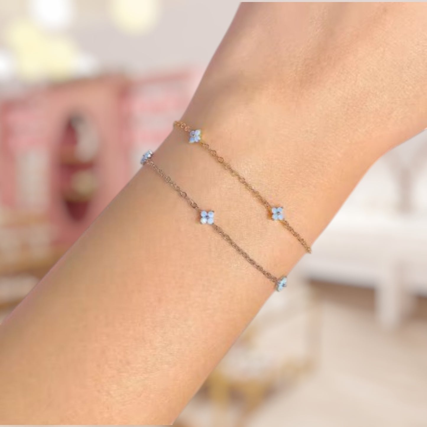 Close-up of a wrist wearing a delicate bracelet with small flowers on a blurred background