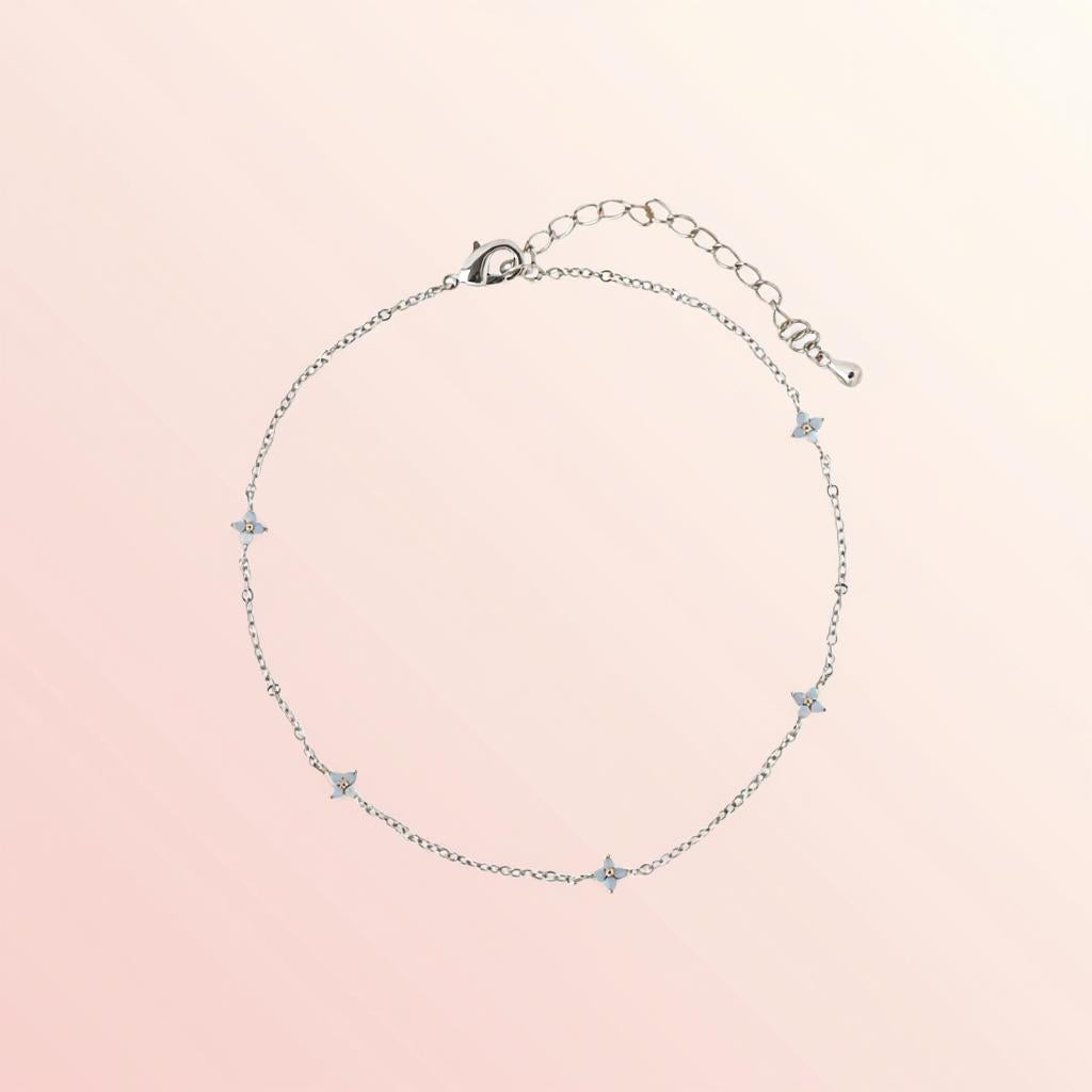 Silver bracelet with star-shaped charms on a pink background