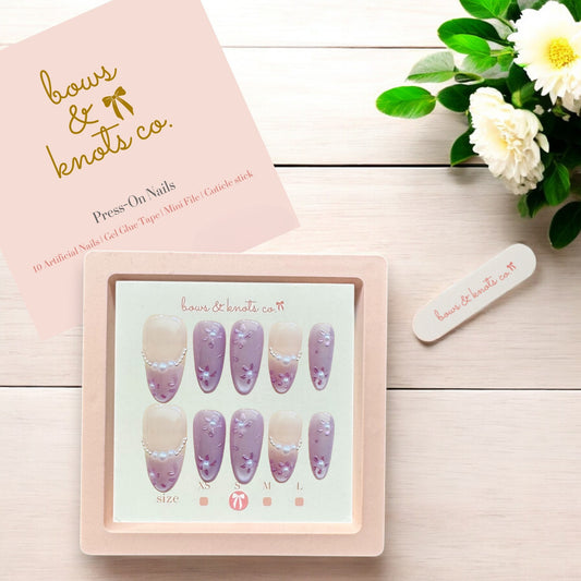 Set of press-on nails with a display card on a wooden surface, featuring the brand 'bows & knots co'.