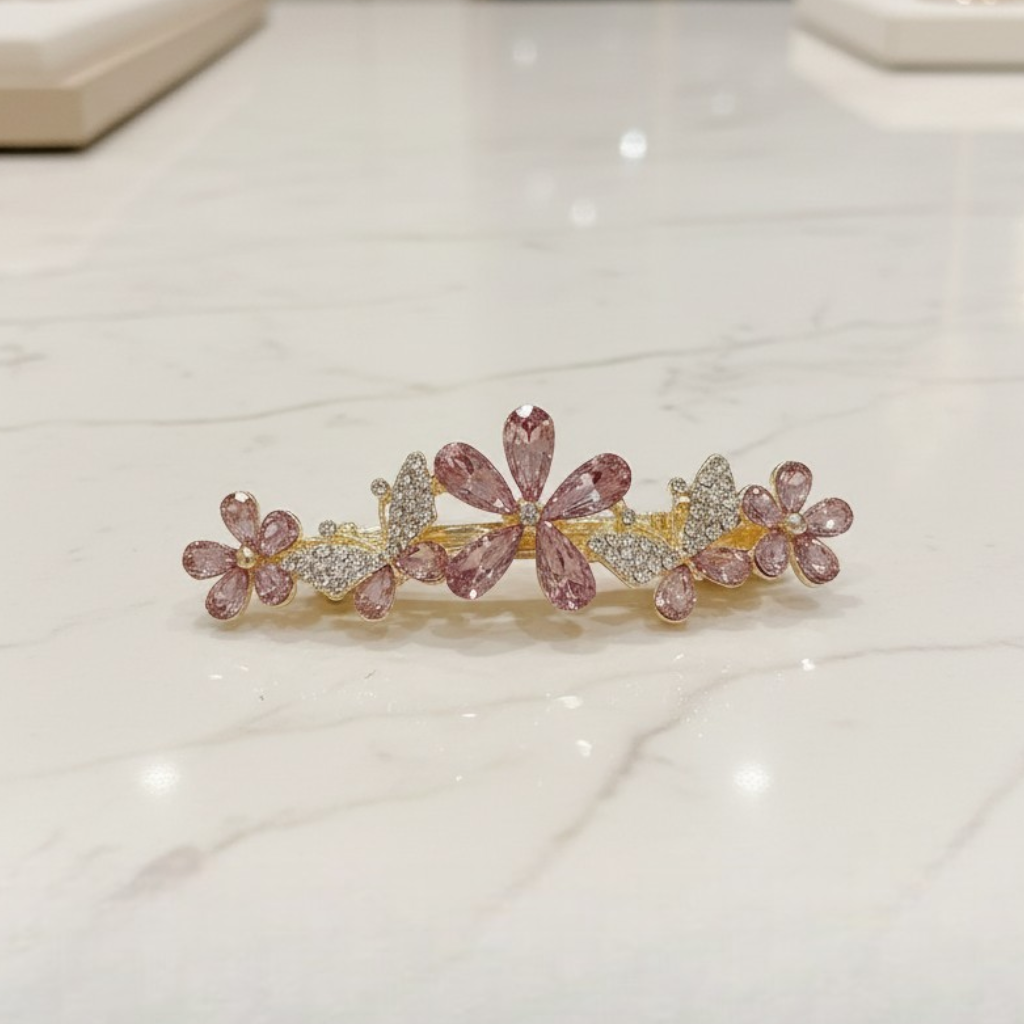 Decorative hair barrette with pink floral and heart designs on a light background