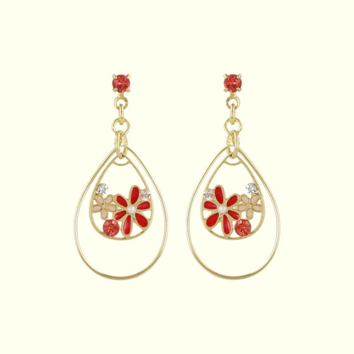 Teardrop-shaped earrings with floral designs and red accents on a white background