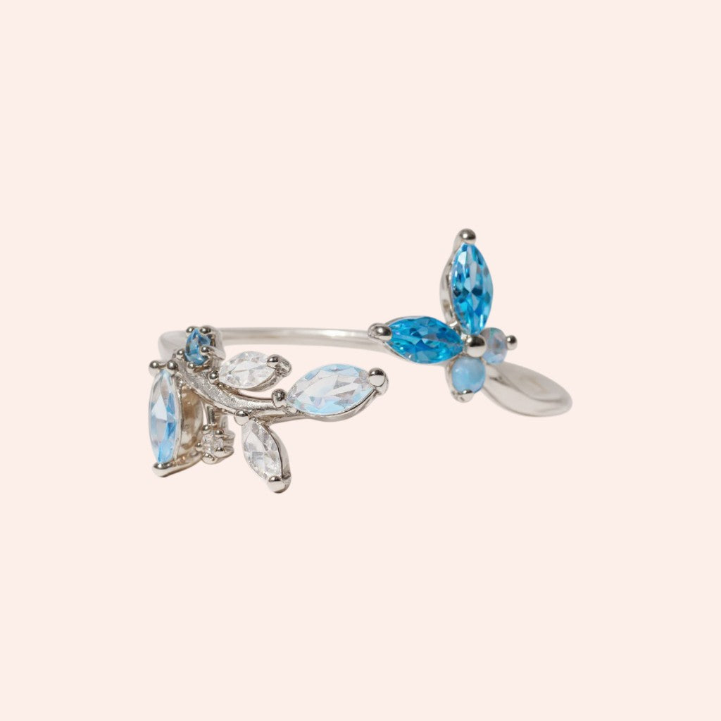 Silver bracelet with blue and clear gemstones on a light beige background