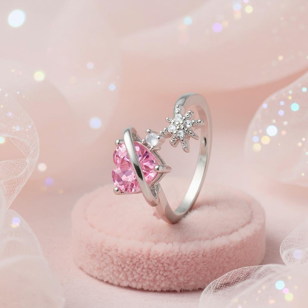 Silver ring with pink gemstone on a pink cushion against a soft pink background