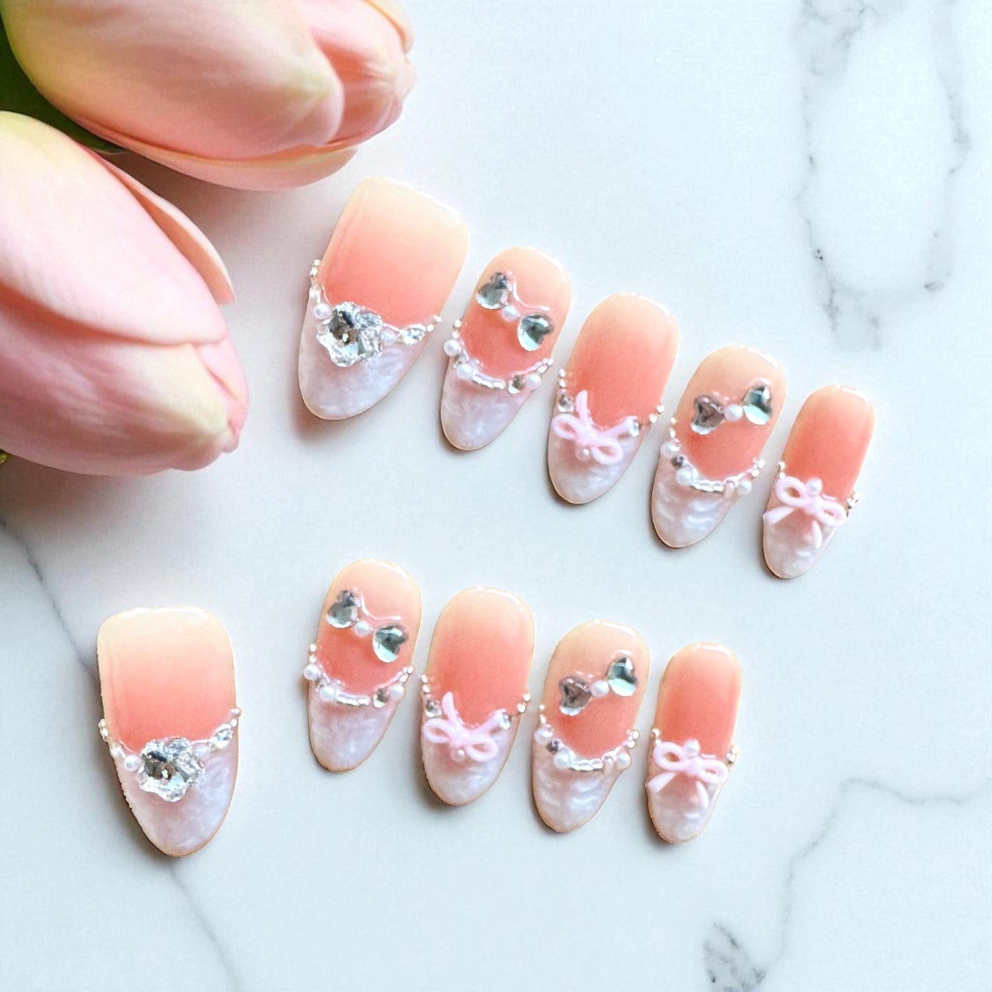 Decorative nail art with pink and white design on a marble background