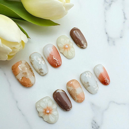 Nail art with floral designs on a marble surface with tulips