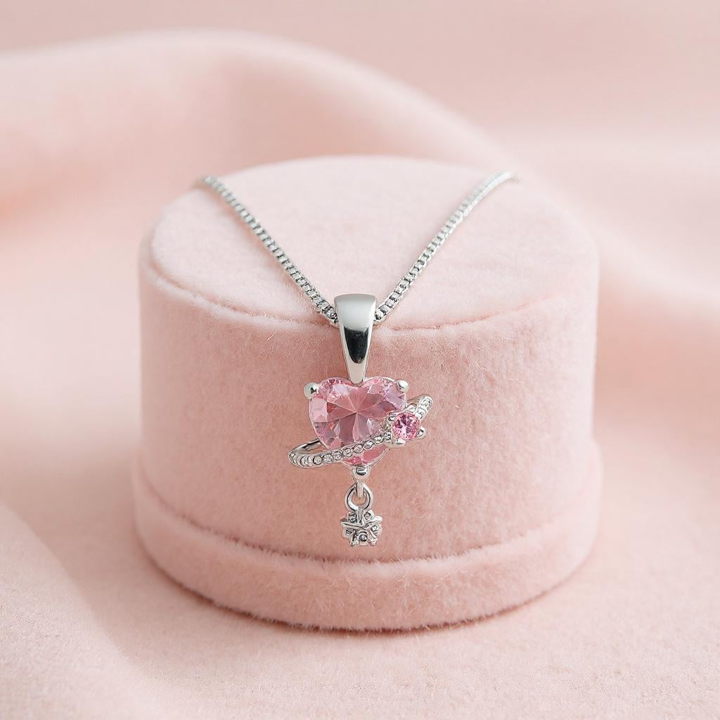 Pink gemstone necklace with silver chain on a pink cushion