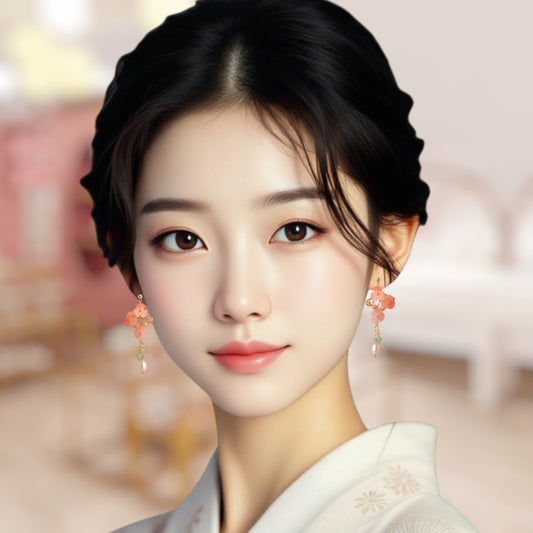 Japanese woman wearing traditional kimono with floral earrings against a blurred background