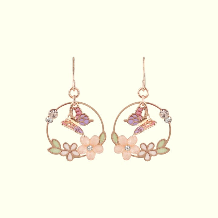 Pair of floral earrings with pink flowers and butterfly designs on a white background