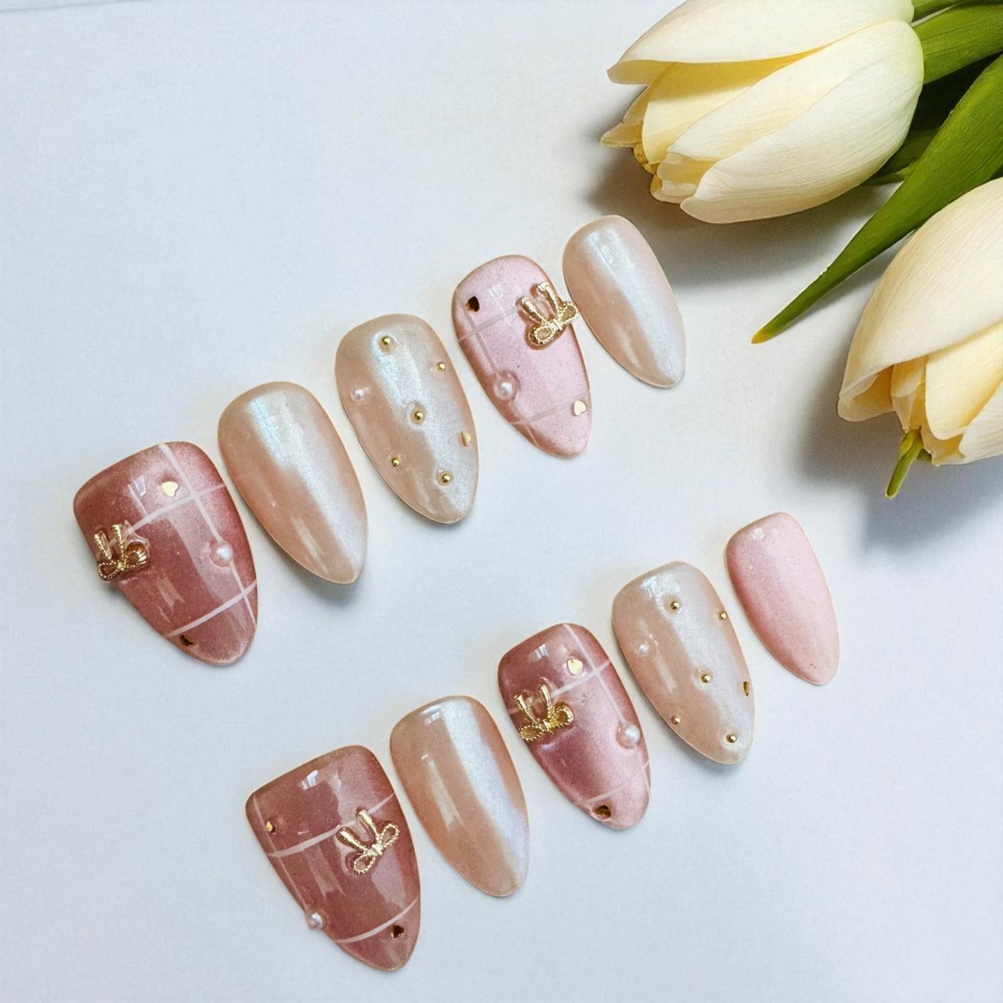 Set of decorative nails with gold accents on a white background with tulips.