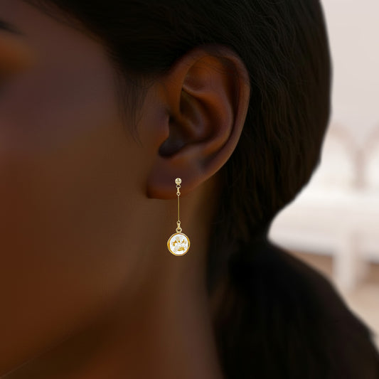 Gold earring worn by a person with a blurred background