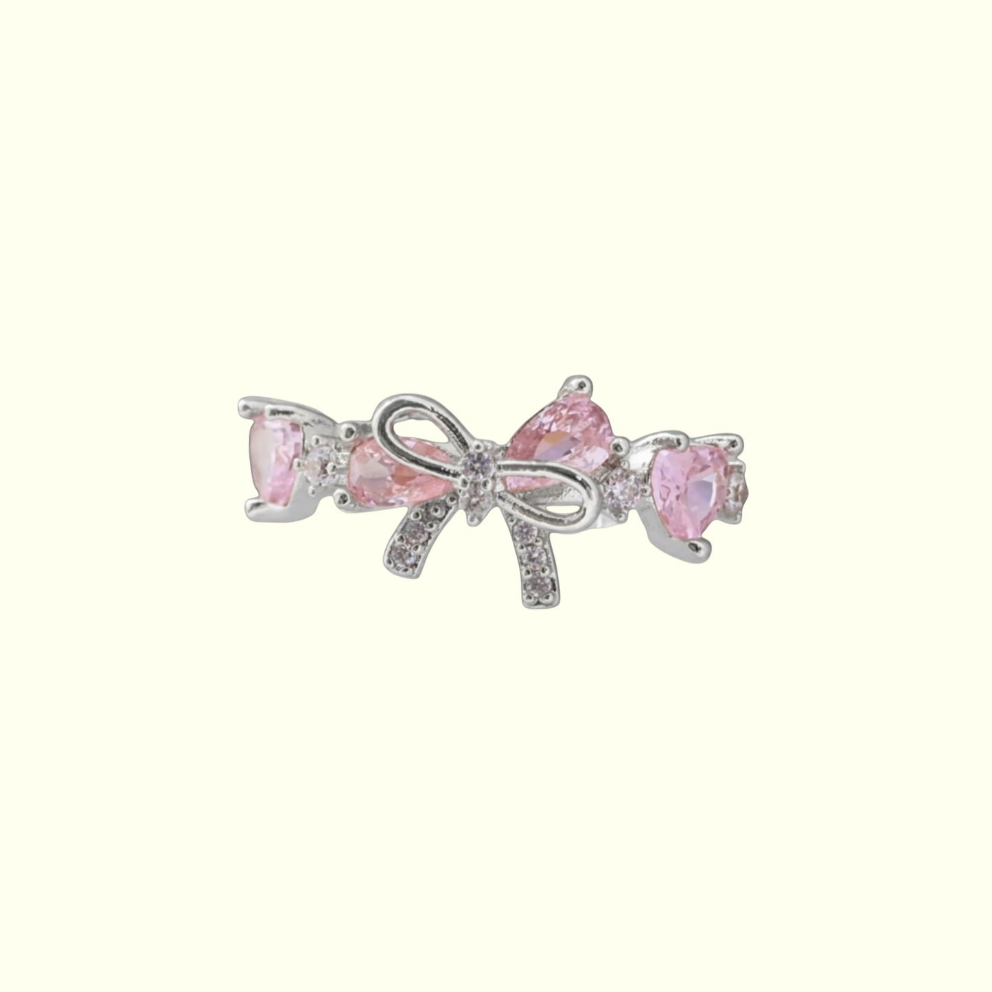 Pink bow-shaped earring with clear gemstones on a white background