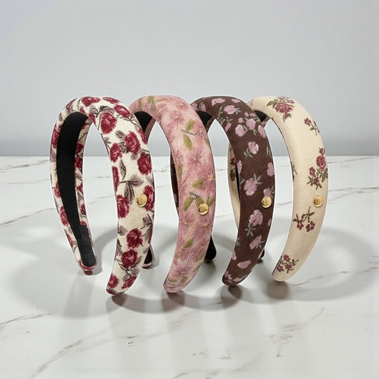 Four floral-patterned headbands on a marble surface