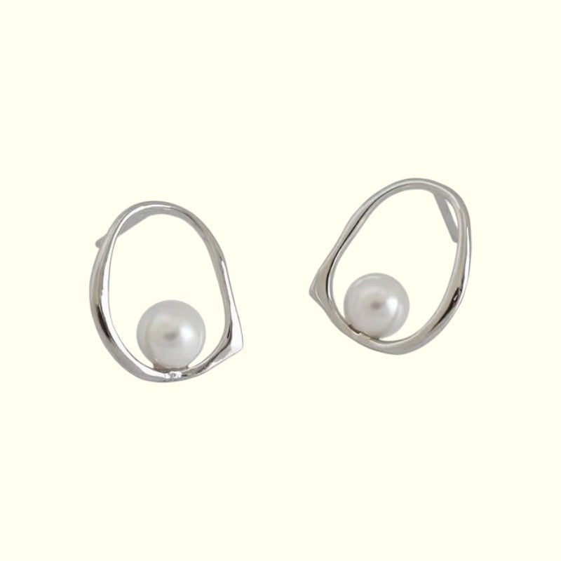 Pair of silver earrings with pearl beads on a white background