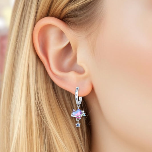 Close-up of an ear wearing a silver earring with a colorful gemstone.