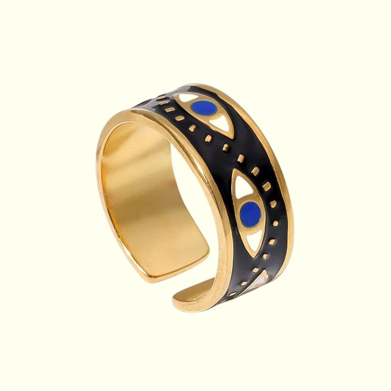 Gold and black evil eye ring with blue accents on a white background