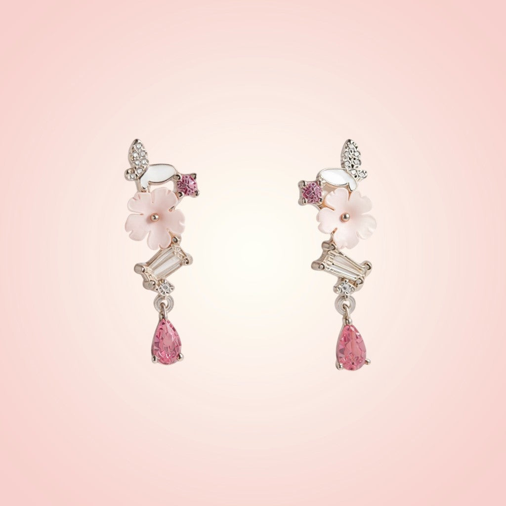 Pair of earrings with pink gemstones on a pink background