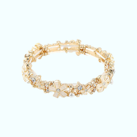 Gold bracelet with floral and crystal design on a white background