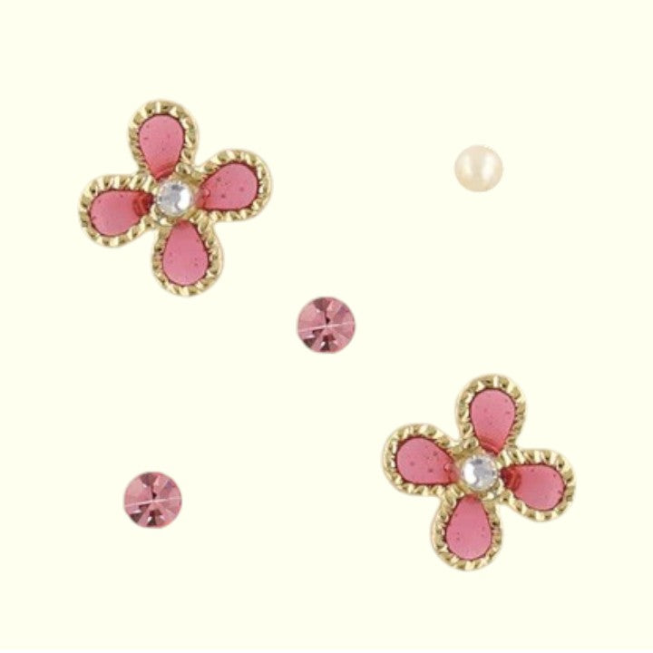 Set of pink flower-shaped earrings with gold accents on a white background