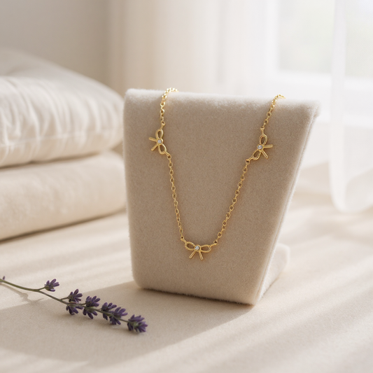 Gold necklace on a beige stand with a soft background