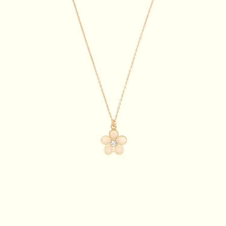 Gold necklace with a flower pendant on a light beige background