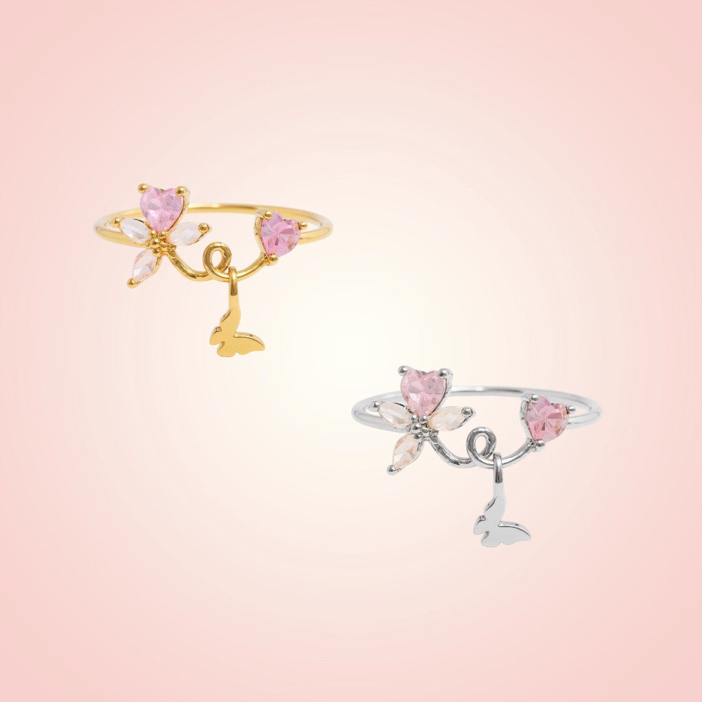 Two decorative rings with pink gemstones on a light pink background