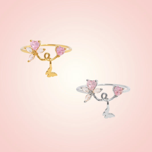 Two decorative rings with pink gemstones on a light pink background