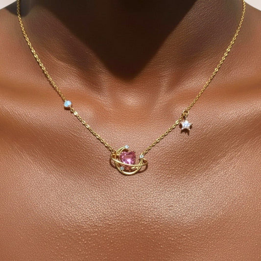 Gold necklace with a pink heart pendant on a brown background