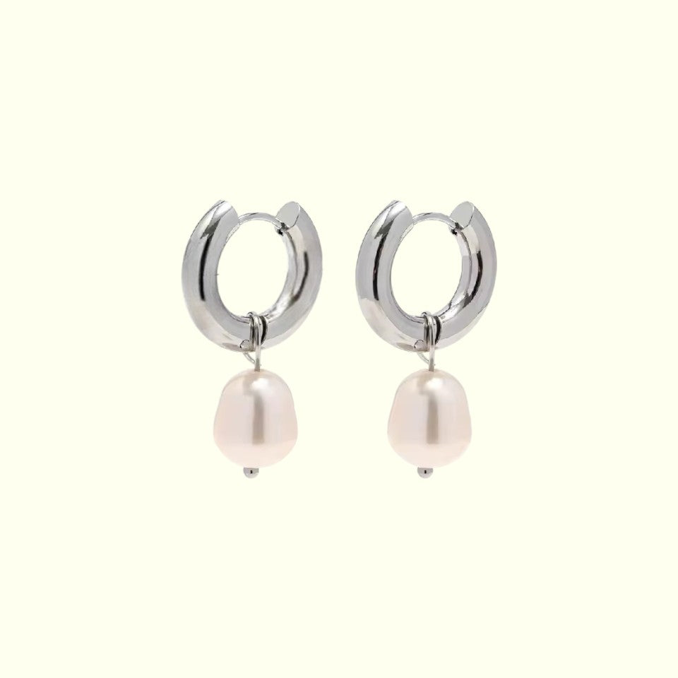 Silver hoop earrings with pink pearls on a white background