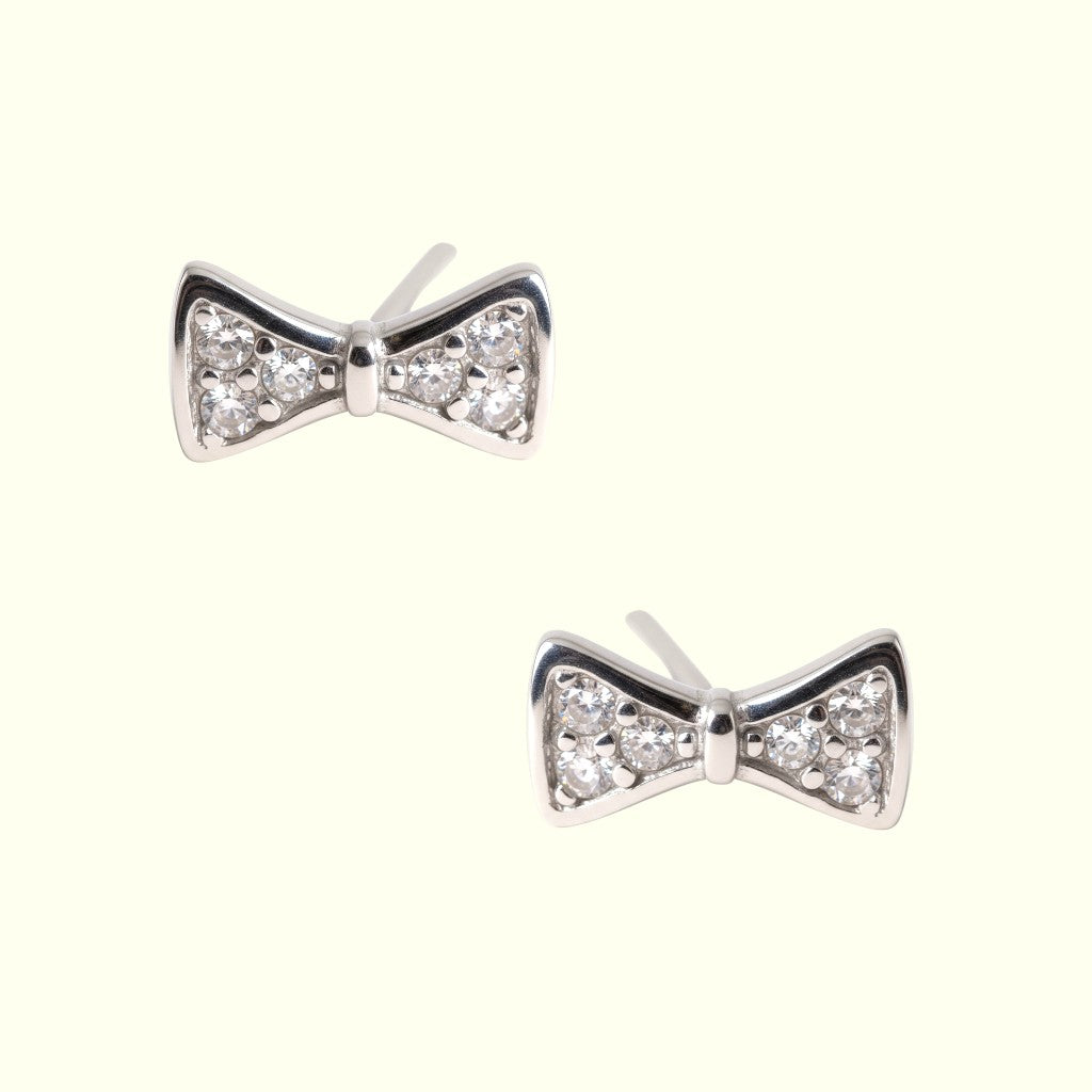 Bow-shaped earrings with diamond-like stones on a white background
