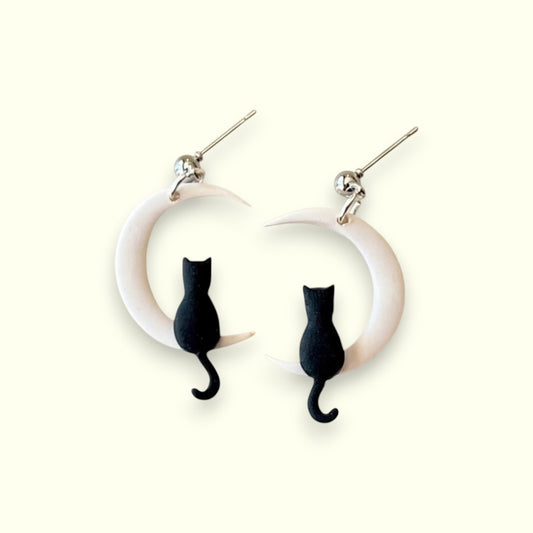 Cat-shaped earrings on a white background