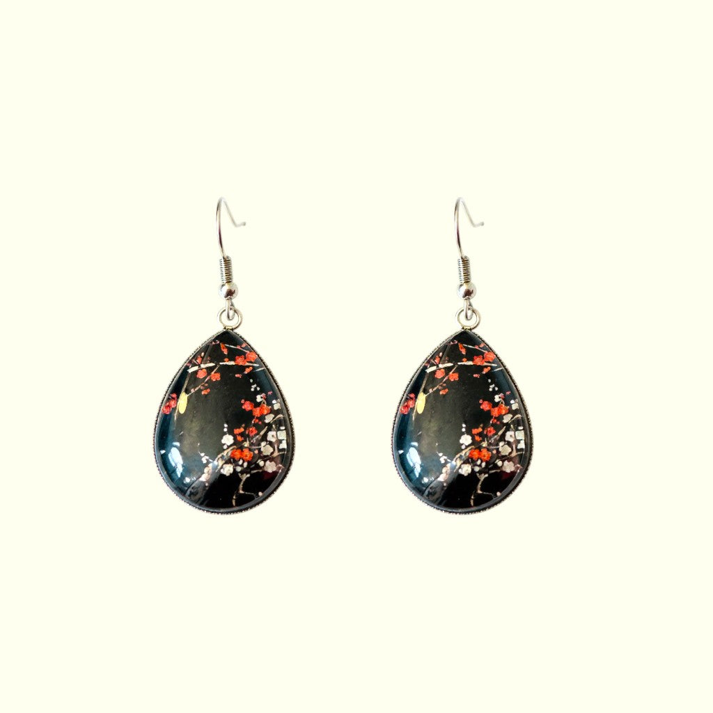 Teardrop-shaped earrings with floral design on a white background