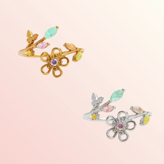 Two pairs of floral ear cuffs, one gold and one silver, on a light pink background.