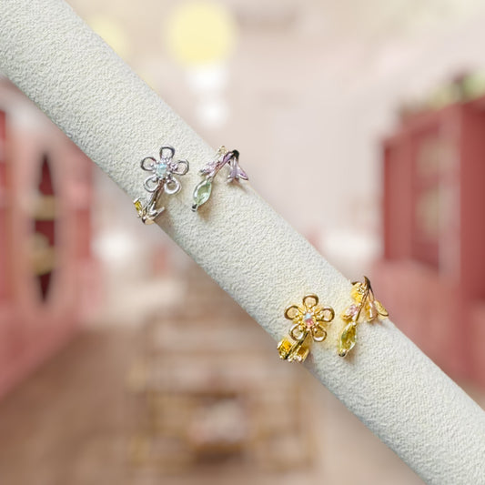 Flower-shaped earrings on a white stand with a blurred background