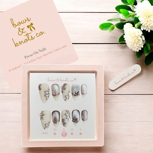 Press-on nails set with a pink box on a wooden surface, featuring 'bows & Knots Co.' branding.
