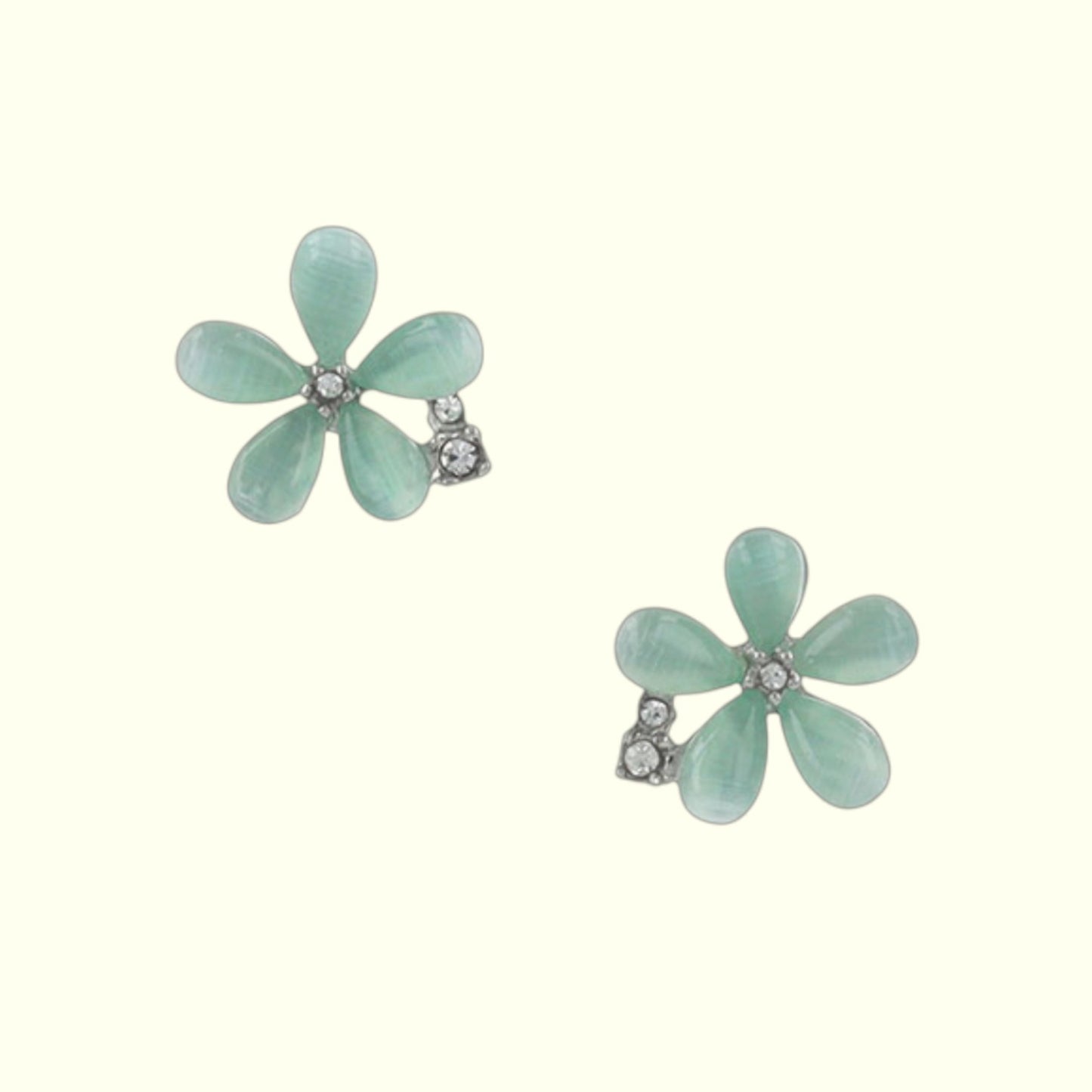 Pair of light blue flower-shaped earrings on a white background
