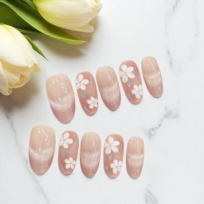 Set of nail art designs with floral patterns on a marble surface with tulips.