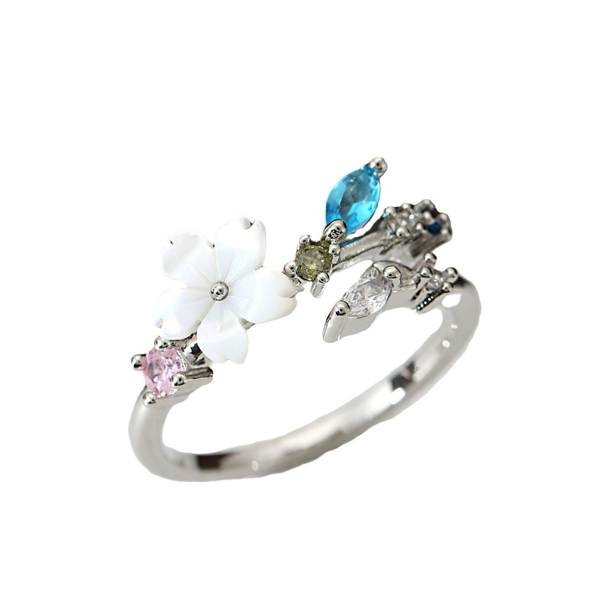 A silver-toned ring designed as a branch with a white flower, a pink gemstone, a blue gemstone, and a green gemstone, shown on a plain white background.