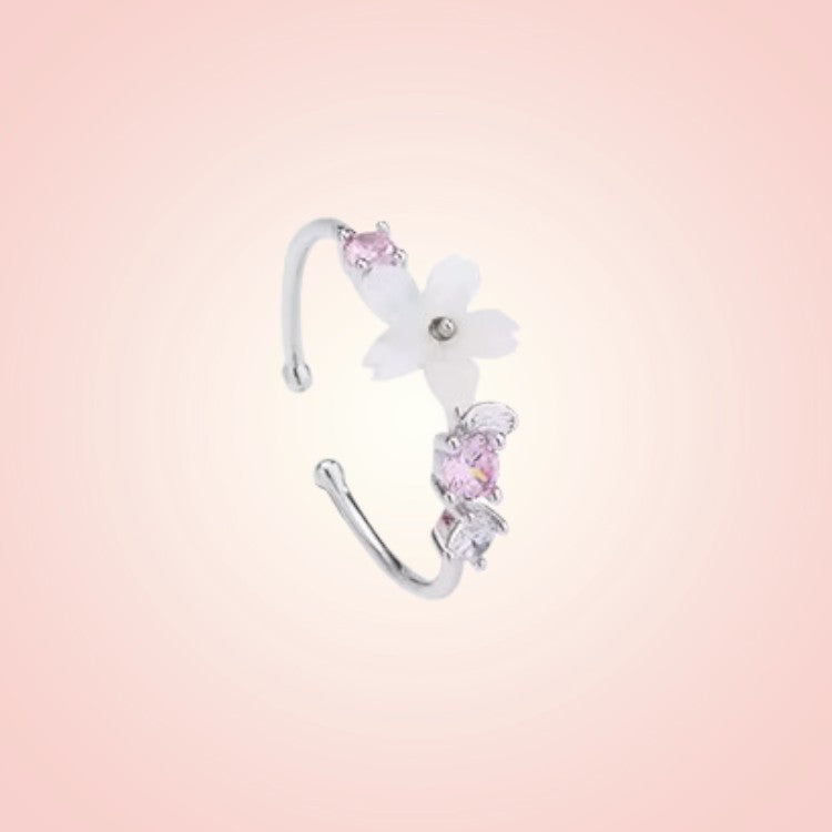 Floral earring with pink gemstones on a gradient pink background
