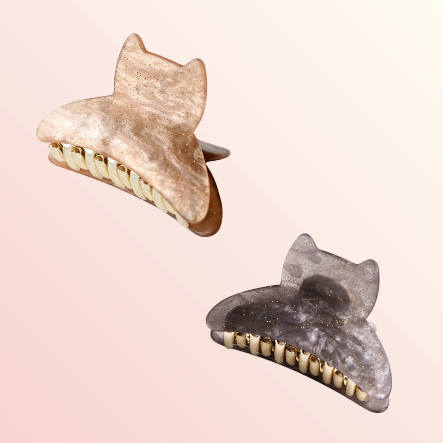 Two marble-textured hair clips on a light pink background