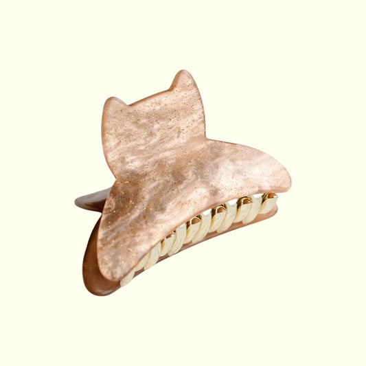 Rose gold shark-shaped hair clip on a white background