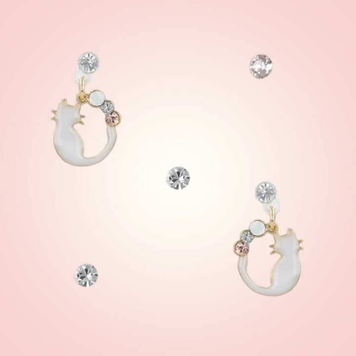 Cat-shaped earrings with gemstones on a pink background