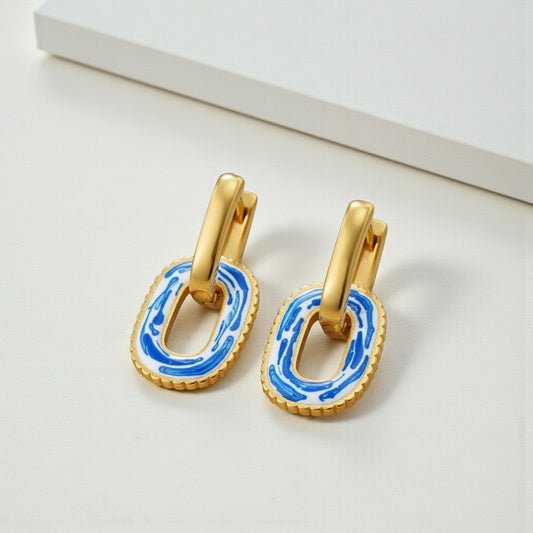 Gold earrings with blue accents on a white background