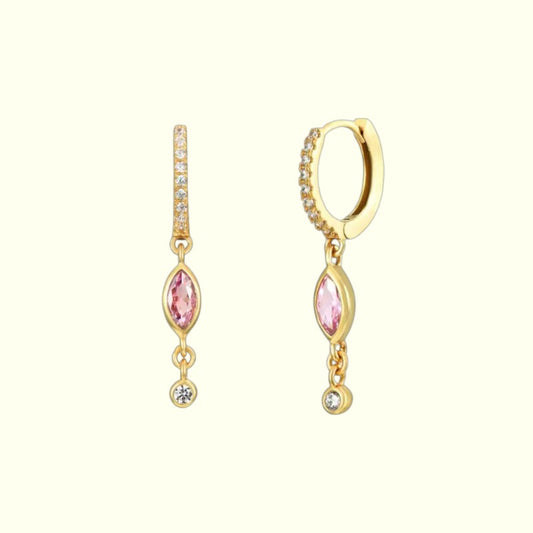 Gold earrings with pink gemstones on a white background