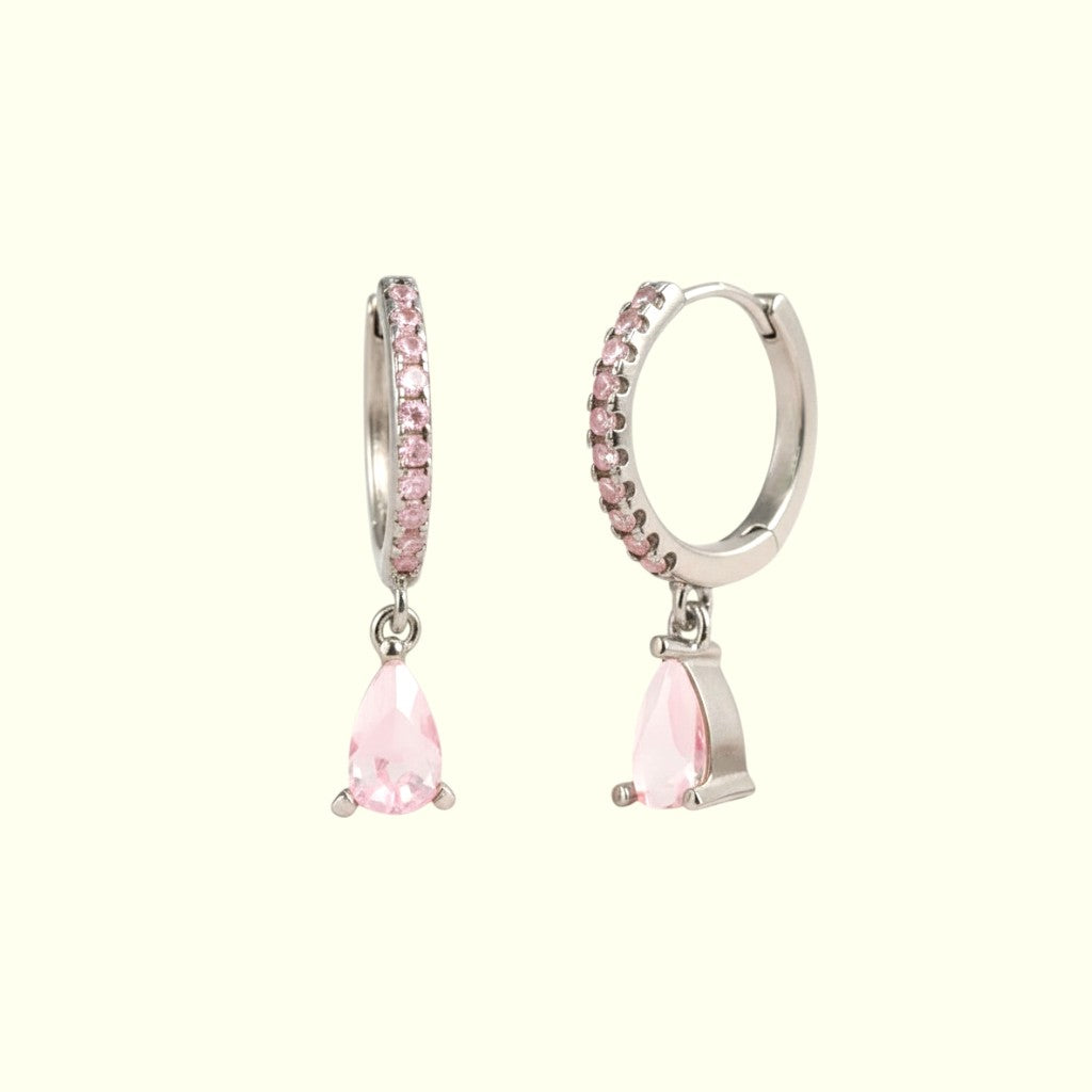 Pair of hoop earrings with pink teardrop stones on a white background